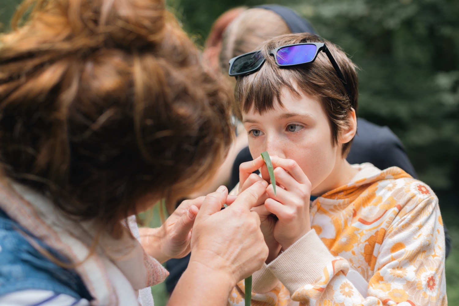 A young person making a grass horn