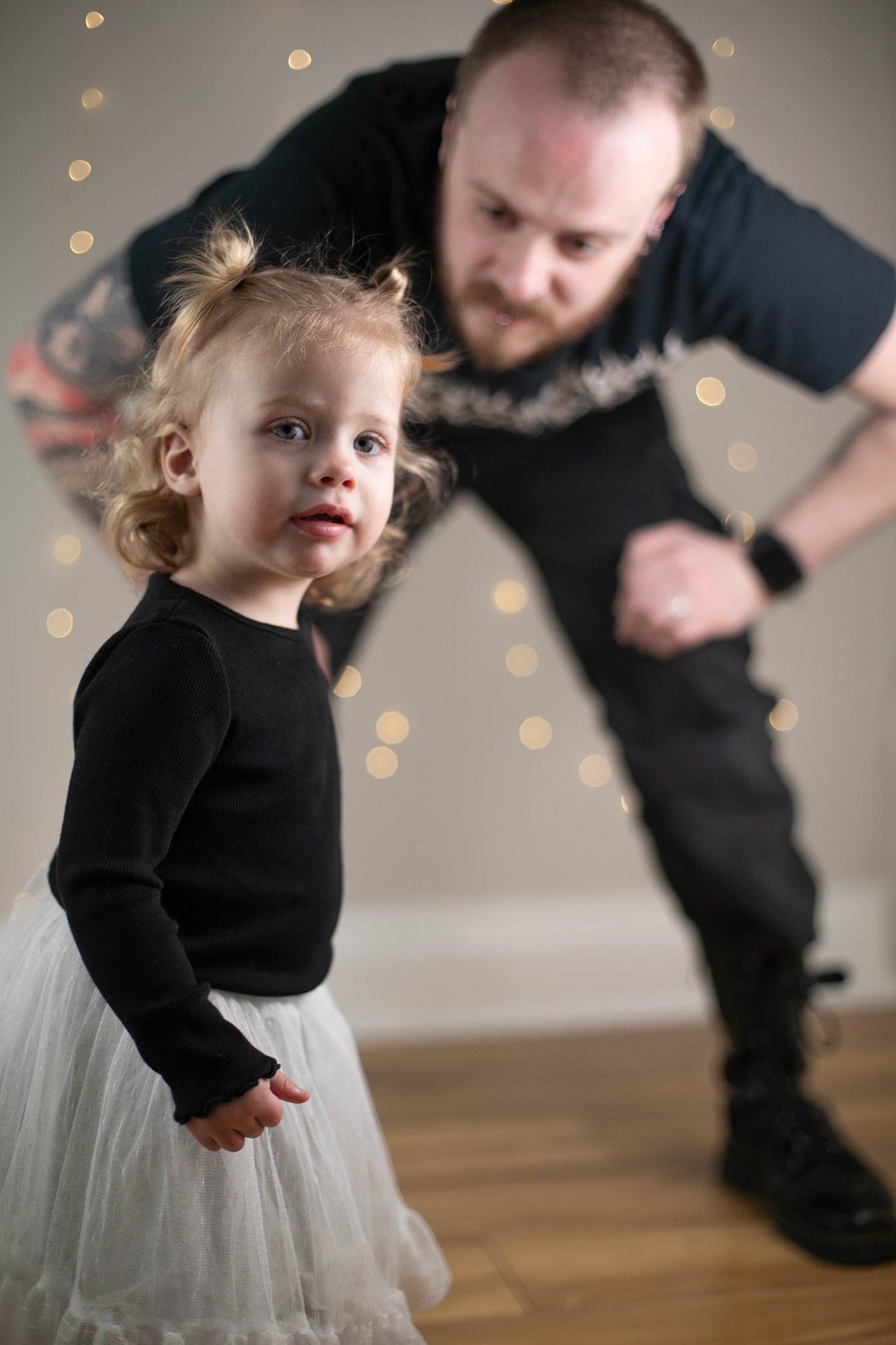 Dad making his toddler laugh during a family photoshoot